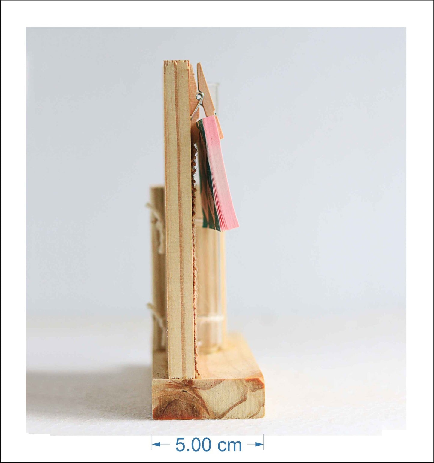 Left view of a wooden pen stand for holding pens and a wooden clip for holding notes.Measurement shown 5 cm wide