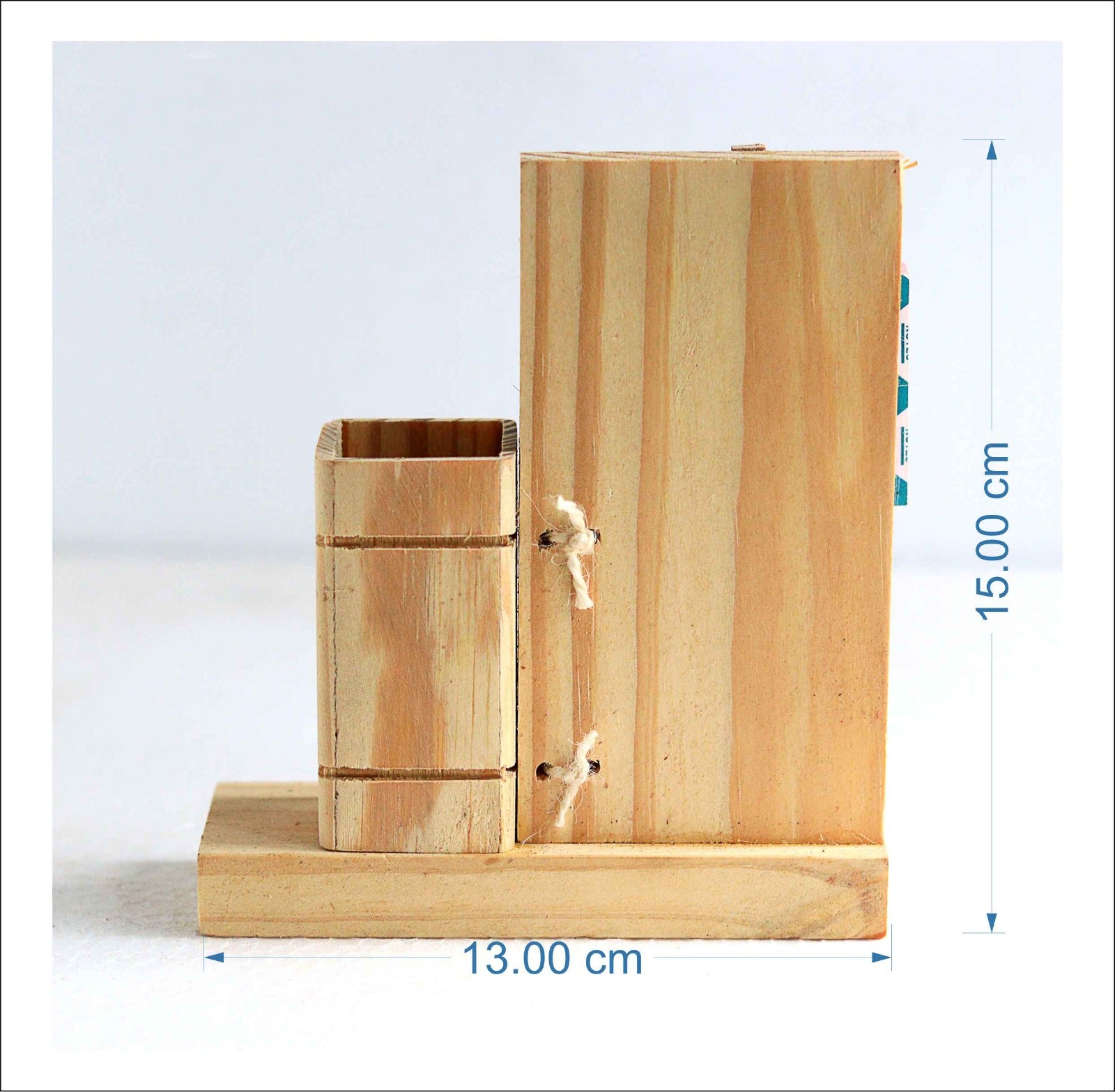 Rear view of a wooden pen stand for holding pens and a wooden clip for holding notes . Measurements shown as 13 cm x 15 cm